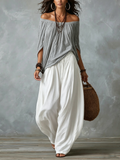 Graues Off-Shoulder-Top und weiße locker sitzende Laternenhose