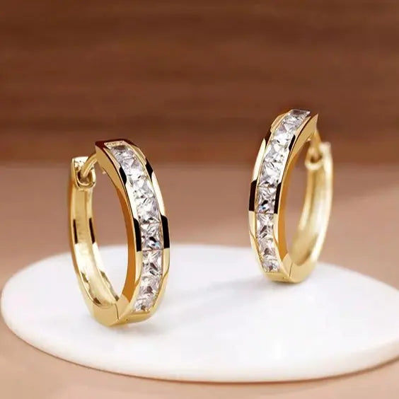 Schicke goldene und kristallene Ohrringe